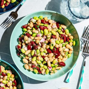 A bowl of vegan four bean salad in the sunlight, ready to serve.