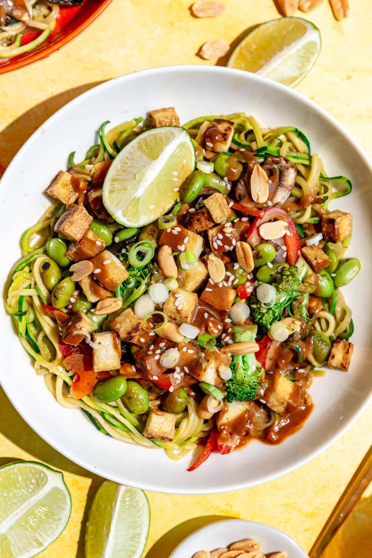 A bowl of zucchini noodle pad Thai, in the sunlight.