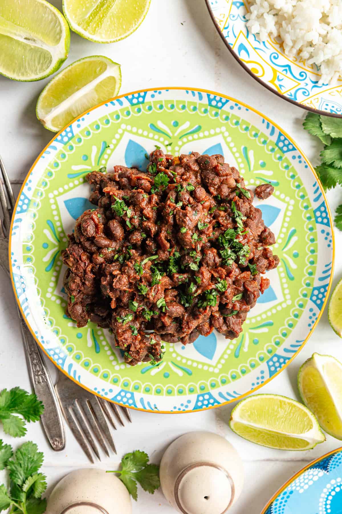 A plate of Quick and Easy Sautéed Black Beans and a plate of rice.
