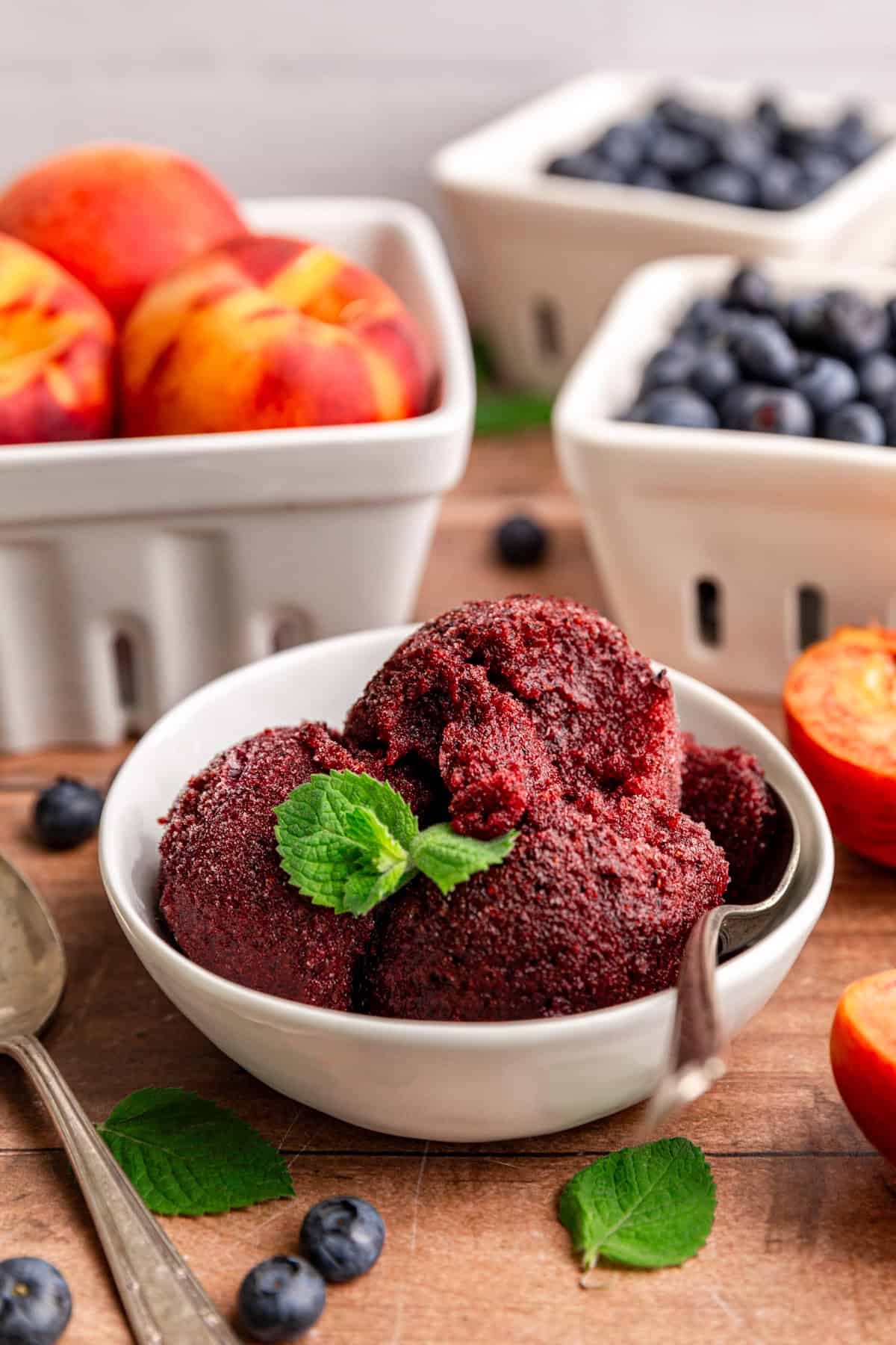 A bowl of Blueberry Peach Sorbet, with a spoon in the bowl and a spoonful removed.