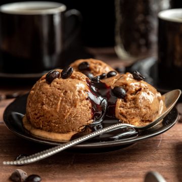 A plate with three scoops of coffee nice cream.