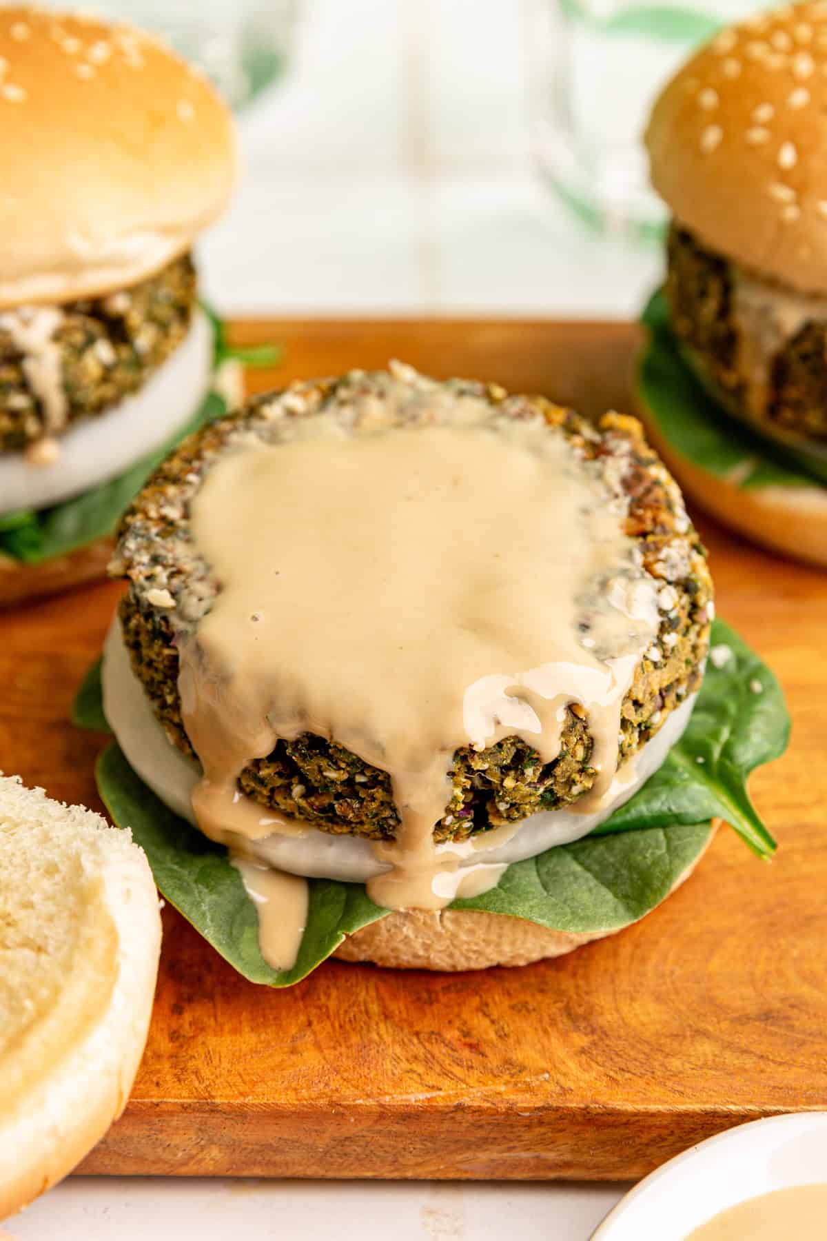 An open-faced falafel burger, dripping with tahini.