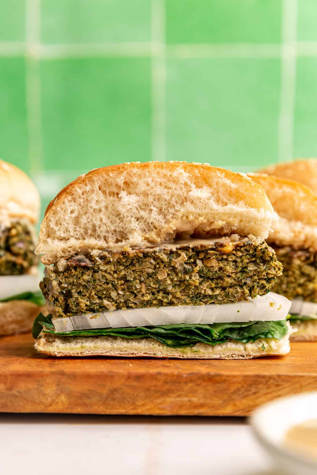 A falafel burger sliced in half to show the firm yet moist texture of the patty.