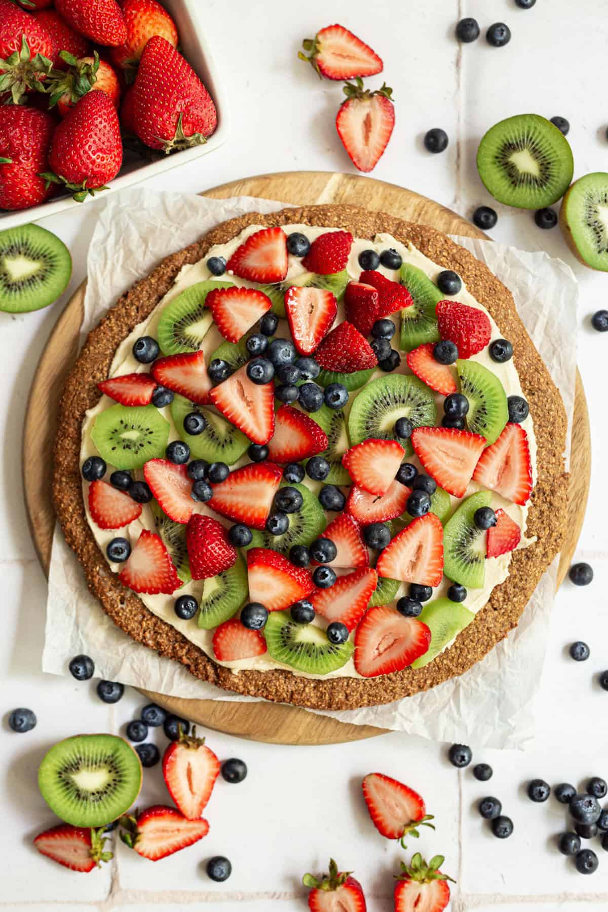 A vegan fruit pizza, ready to slice.