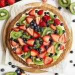 A vegan fruit pizza, ready to slice.
