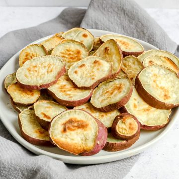 A plate of roasted japanese sweet potato rounds.