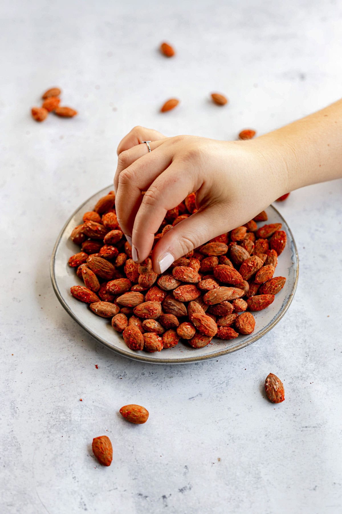 A person reaching for a smoked paprika almond.