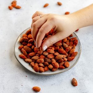A person reaching for a smoked paprika almond.
