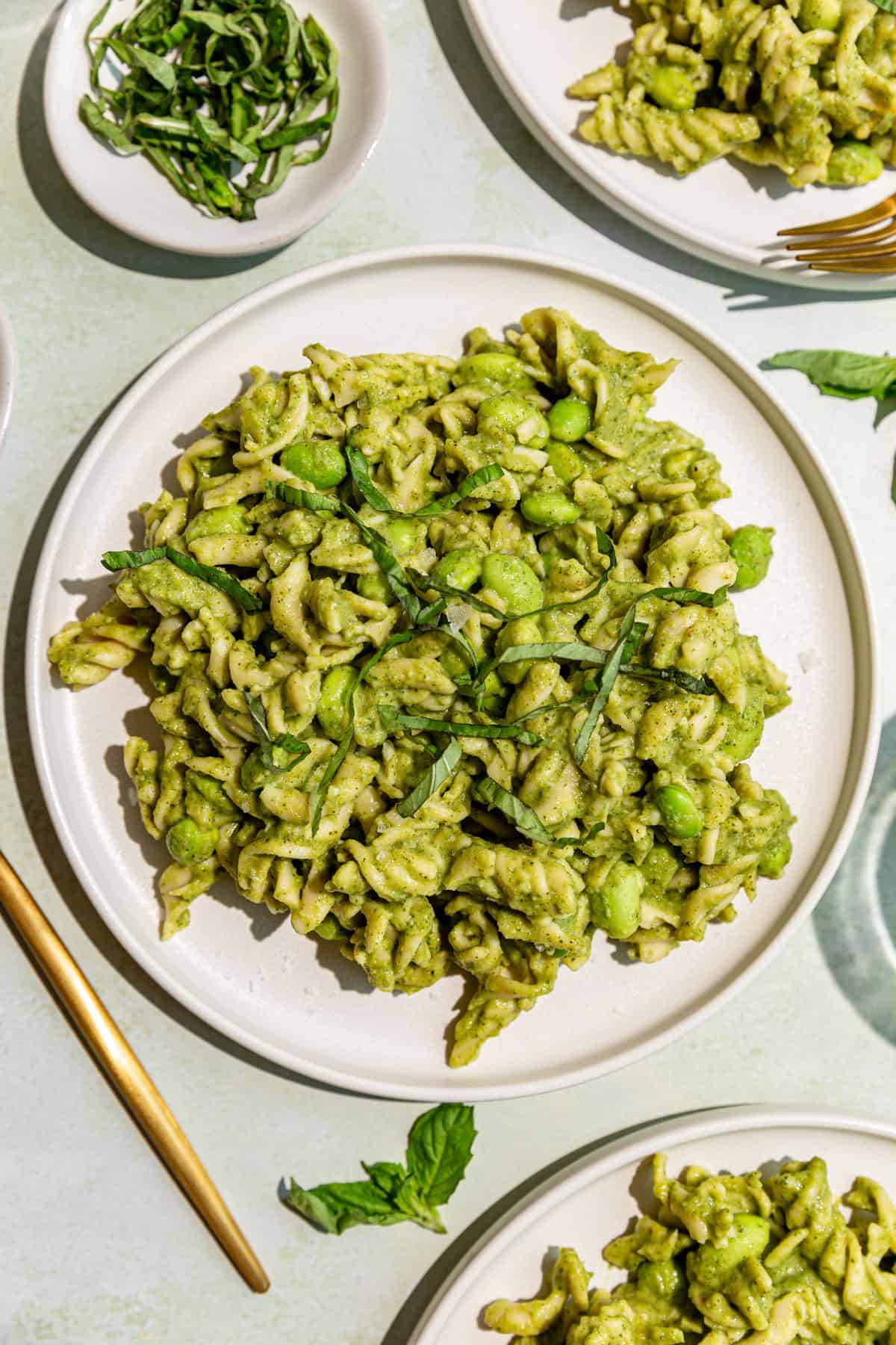 Several plates of vegan broccoli pasta, ready to eat.