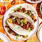 Three seitan tacos on a plate.