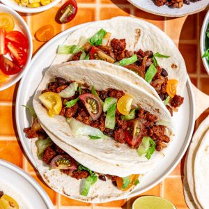 Three seitan tacos on a plate.