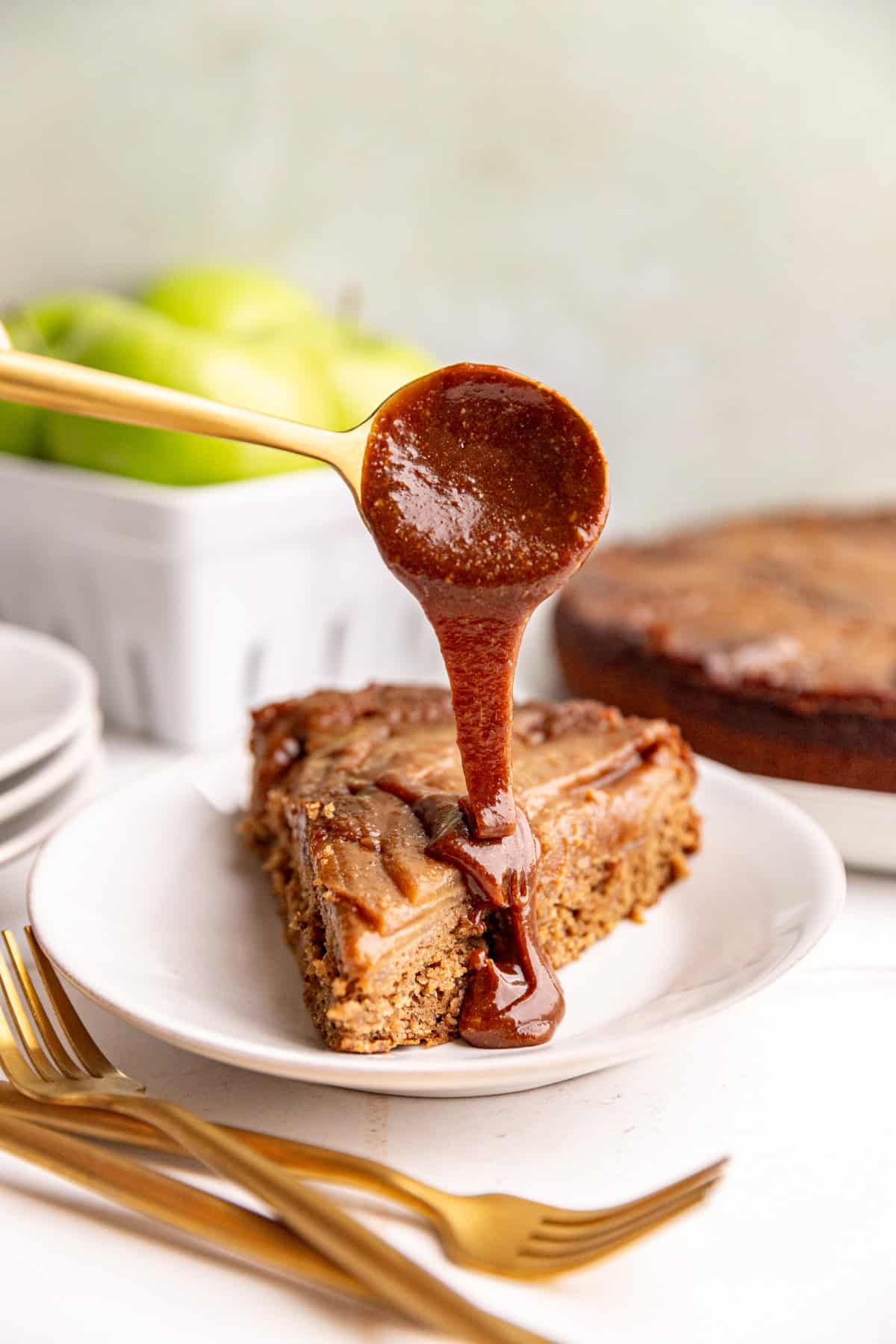 Caramel being poured onto a slice of vegan apple upside down cake.