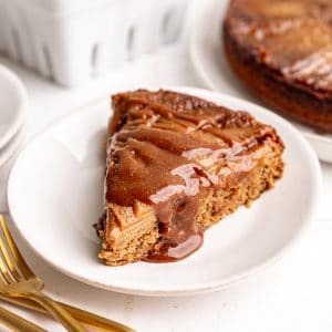 A slice of Vegan Apple Upside Down Cake, with a drizzle of caramel on top.