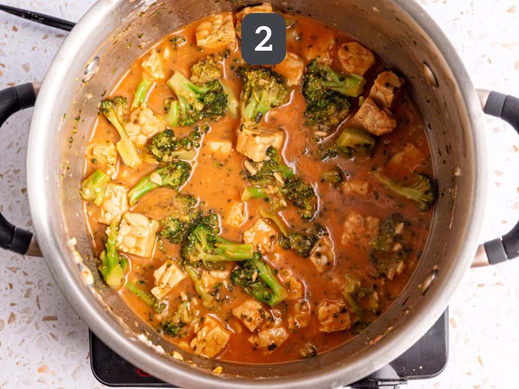 Vegan creamy spinach pasta step 2 - cook the broccoli, tempeh, cream cheese, and tomato paste.