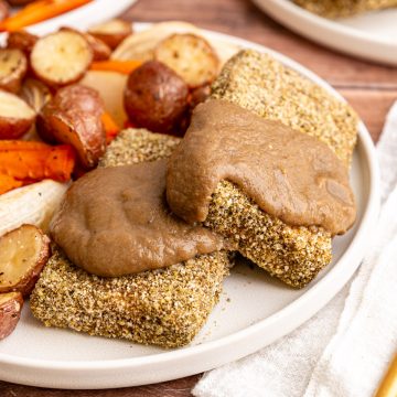Two slices of Thanksgiving Tofu on a plate, covered with mushroom gravy.