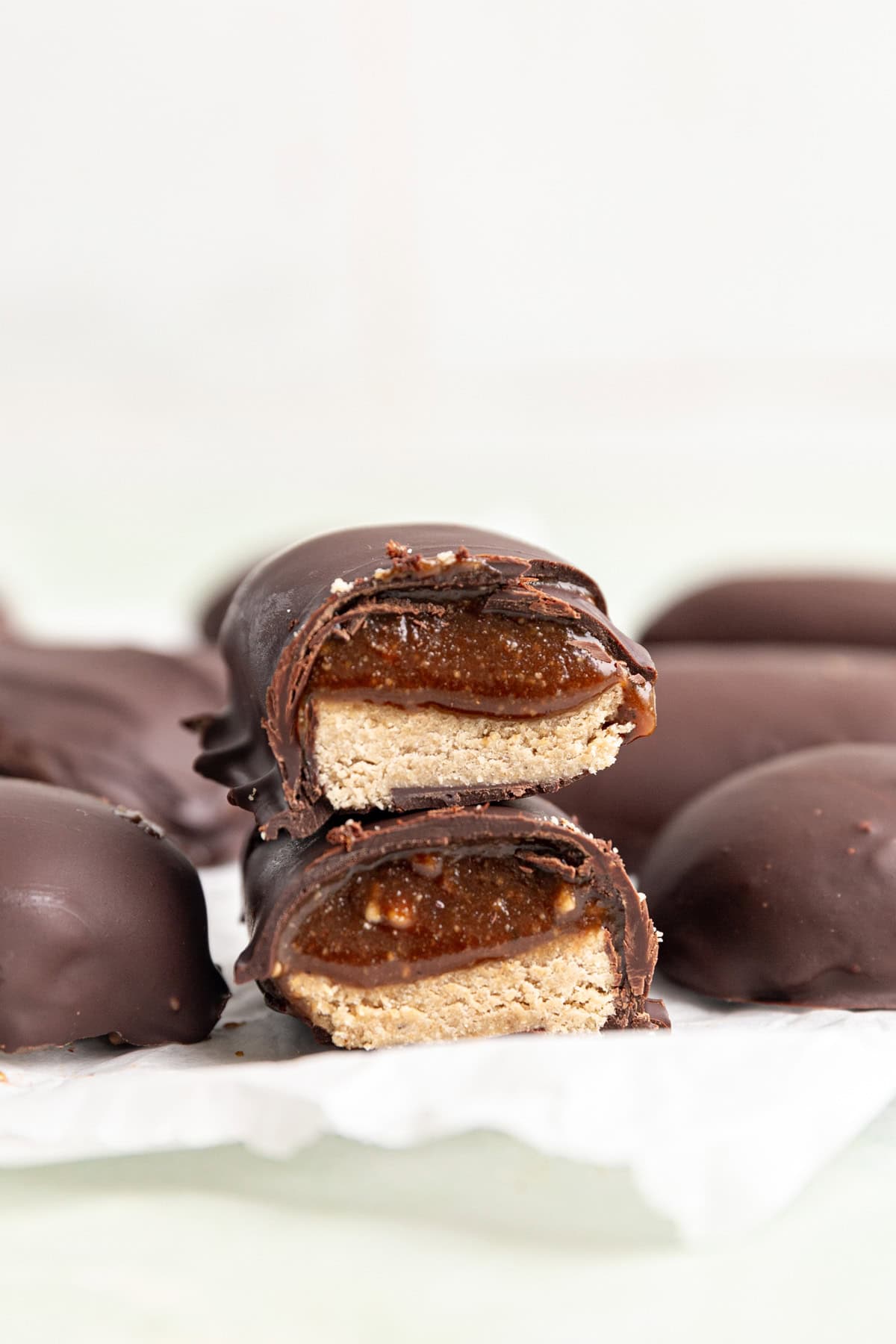 Two halves of a milky way bar on a piece of parchment paper.