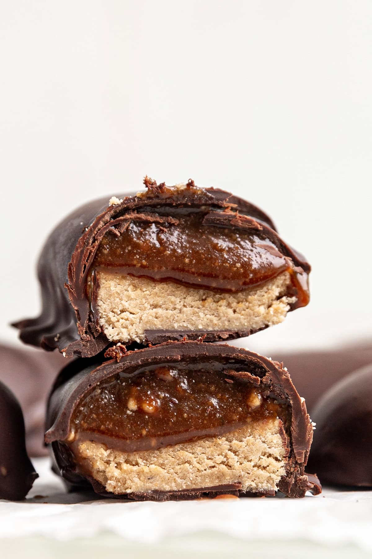 Two halves of a milky way bar on a piece of parchment paper.