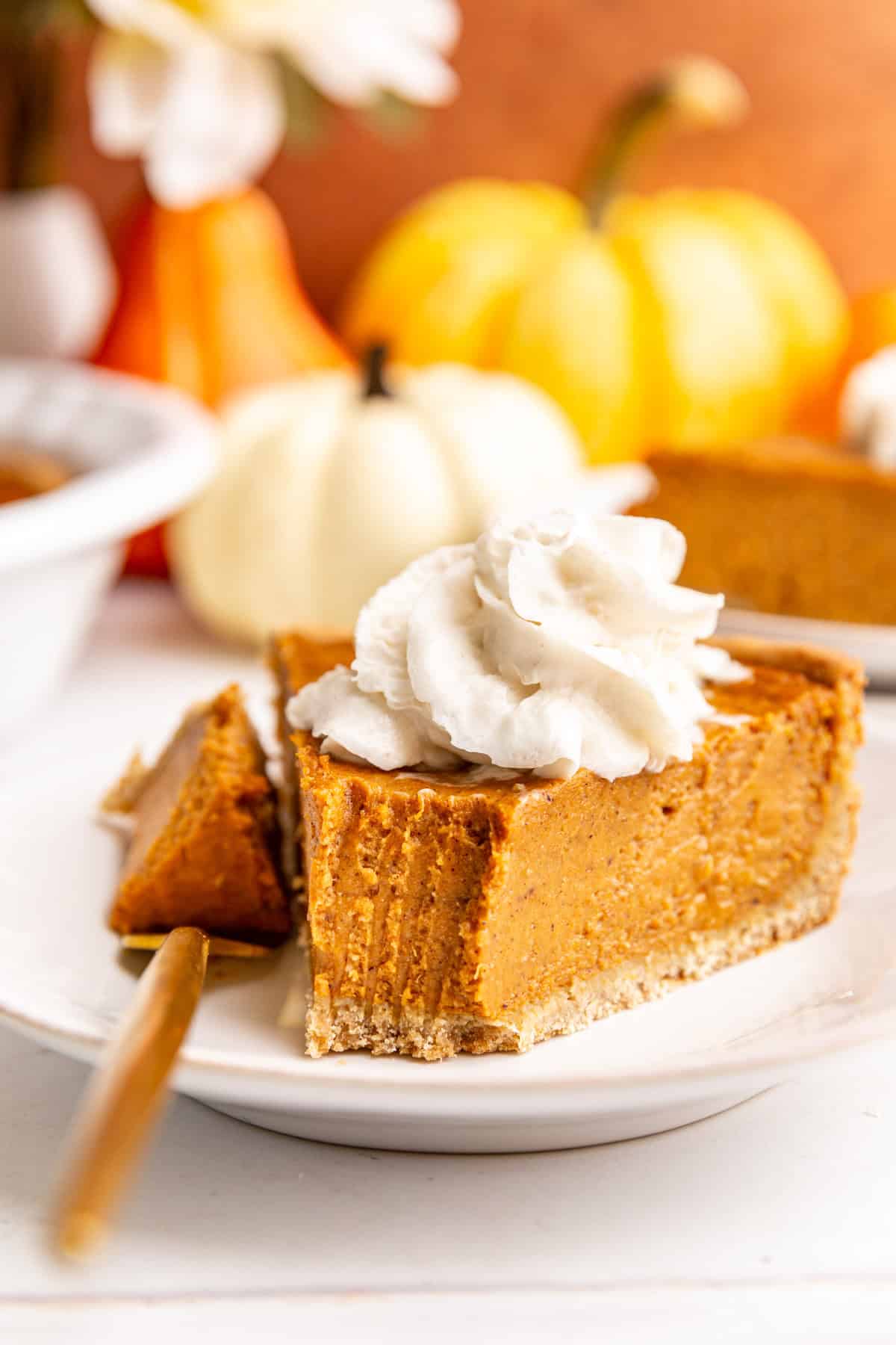 A piece of vegan gluten free pumpkin pie, with a bite taken out.