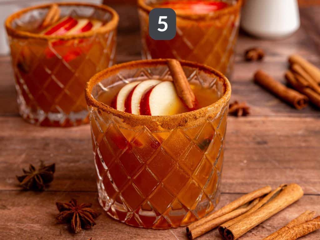 Thanksgiving Mocktail Step 5 - strain into glasses and garnish with apple slices.