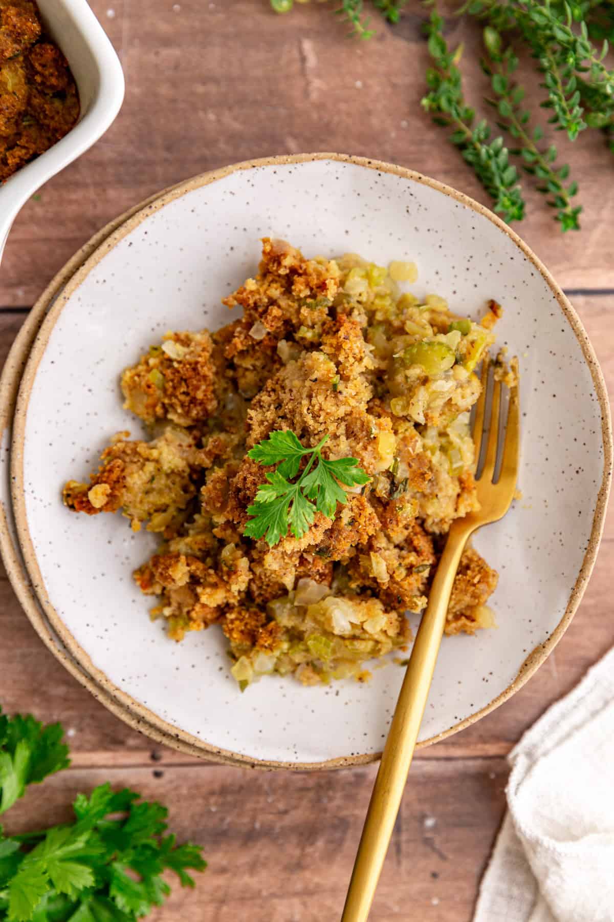 A bowl of cornbread stuffing, with a fork, ready to eat.