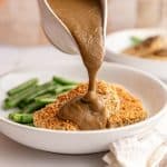Vegan mushroom gravy being poured onto tofu.