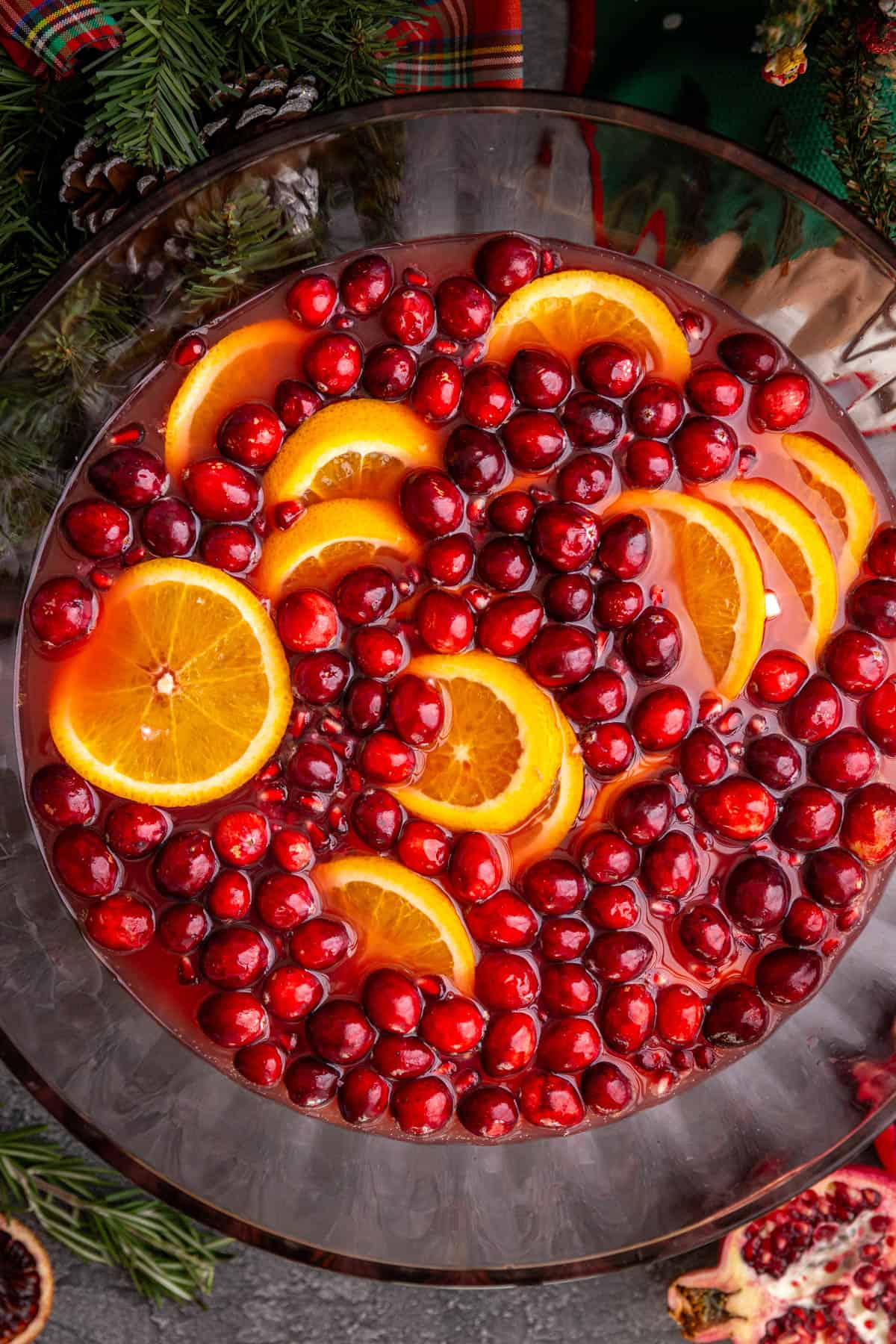 A top-down view of a punch bowl, with cranberries and oranges floating on top.