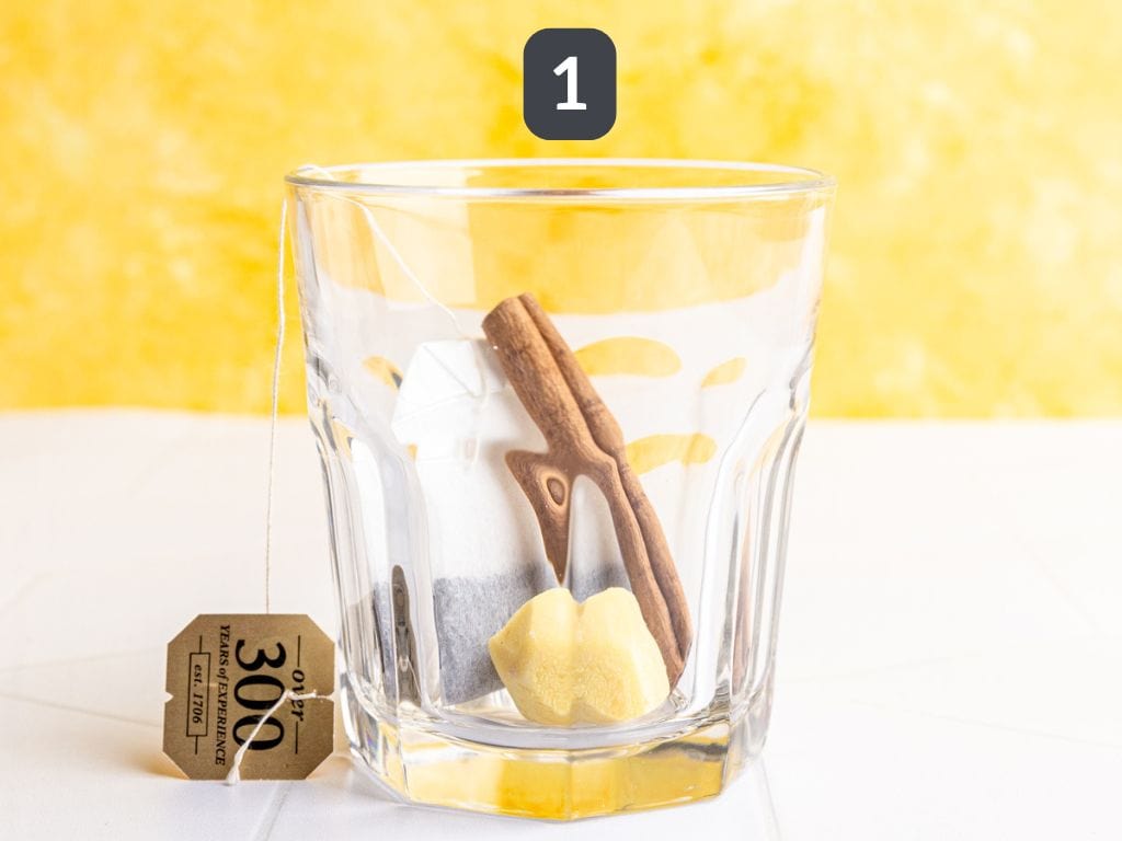 Non alcoholic hot toddy step 1 - add the tea, cinnamon, and ginger to a glass.