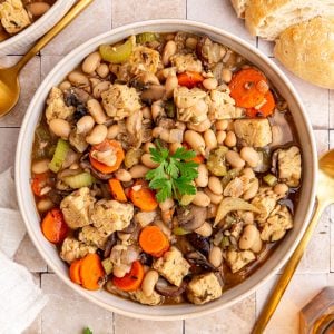A bowl of vegan cassoulet garnished with fresh parsley.