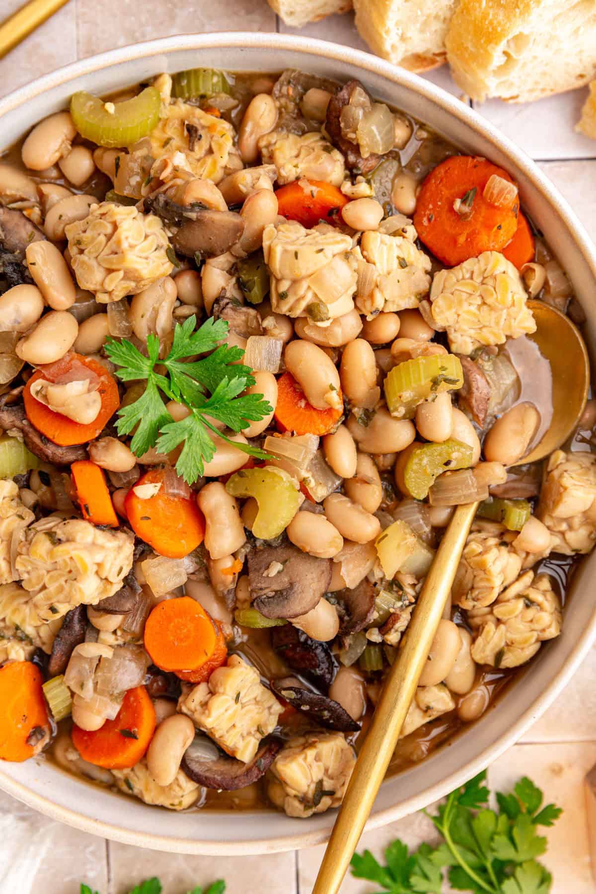 A bowl of vegan cassoulet with a spoon.