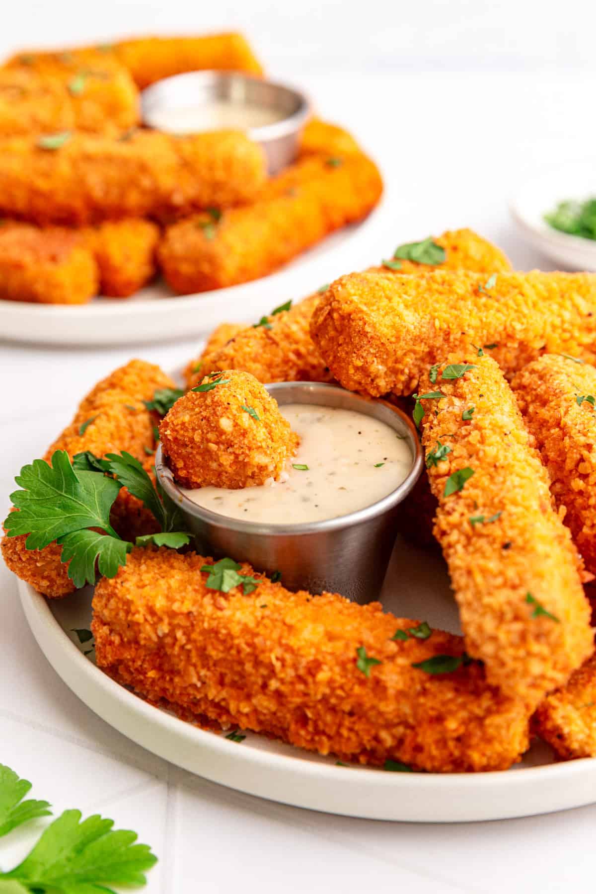 A piece of a tofu wing dunked in vegan ranch.