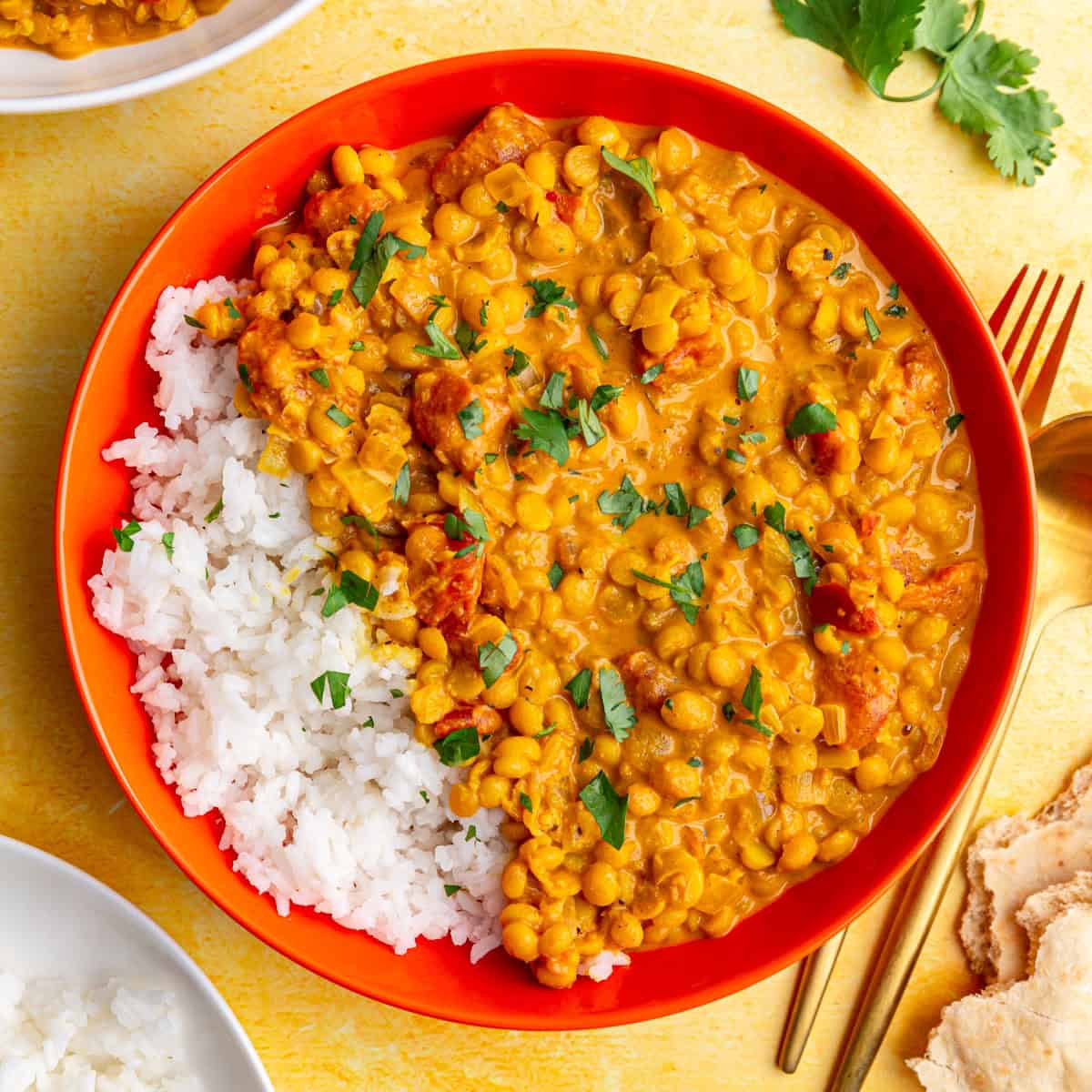 A bowl of white rice and chickpea dal, ready to eat.