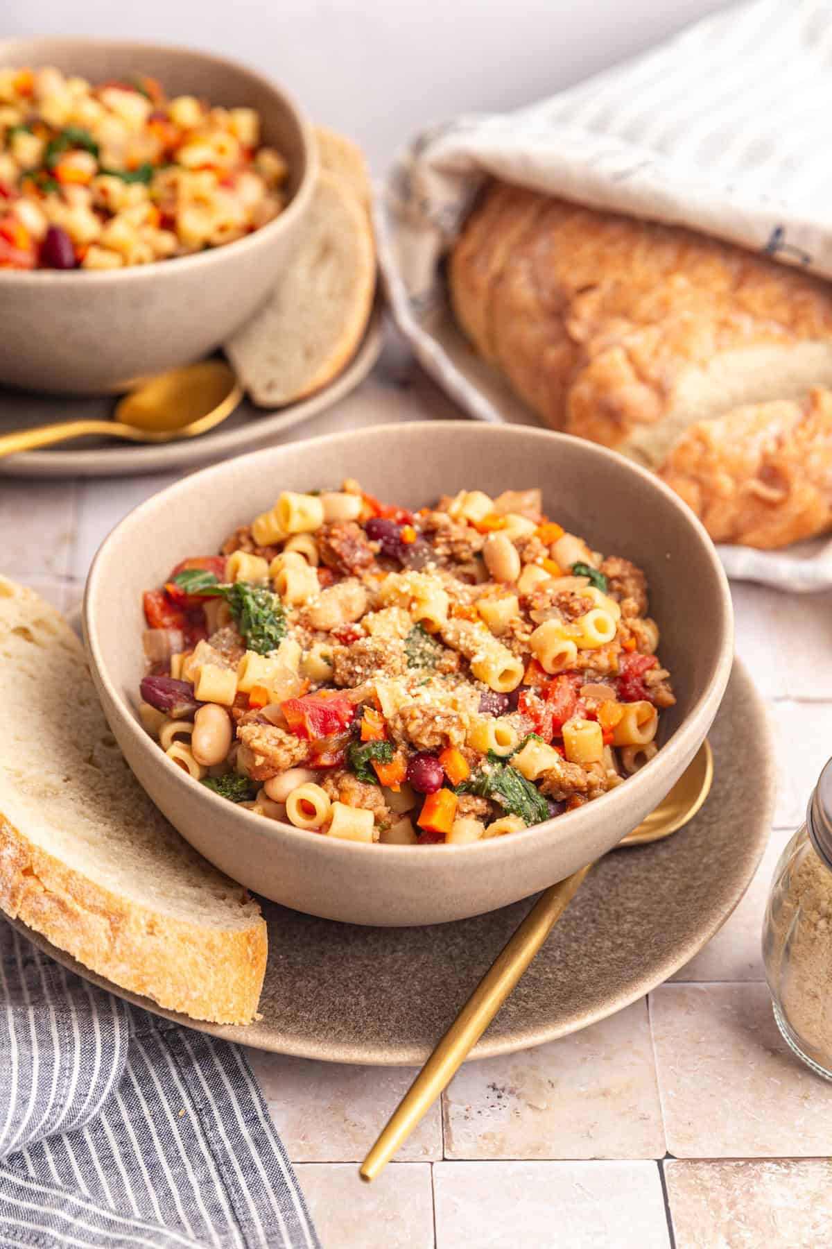 Several bowls of pasta e fagioli soup, served with bread.