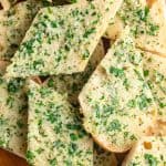 Slices of vegan garlic bread on a cutting board.