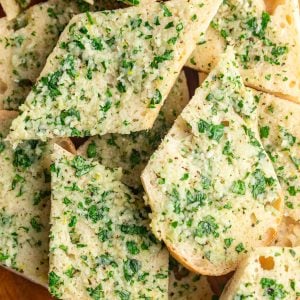 Slices of vegan garlic bread on a cutting board.