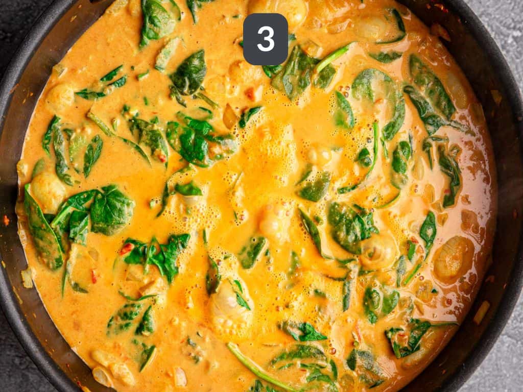 Butter bean curry step 3 - add the coconut milk, tomatoes, beans, and spinach.