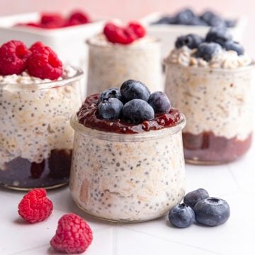 Several jars of coconut milk overnight oats, with fruit and jam.