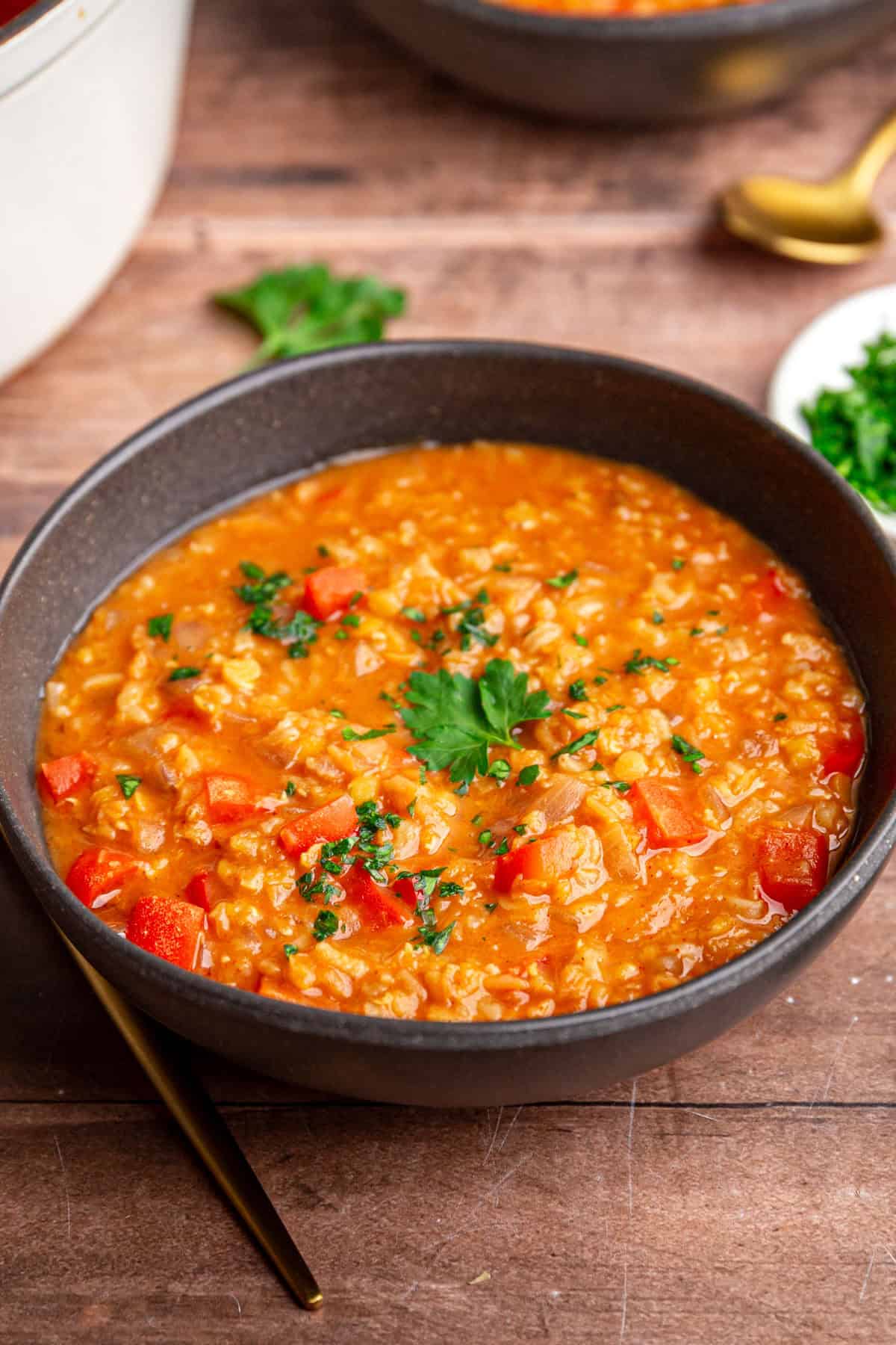 A bowl of Red Pepper Red Lentil Soup with a spoon, ready to eat.