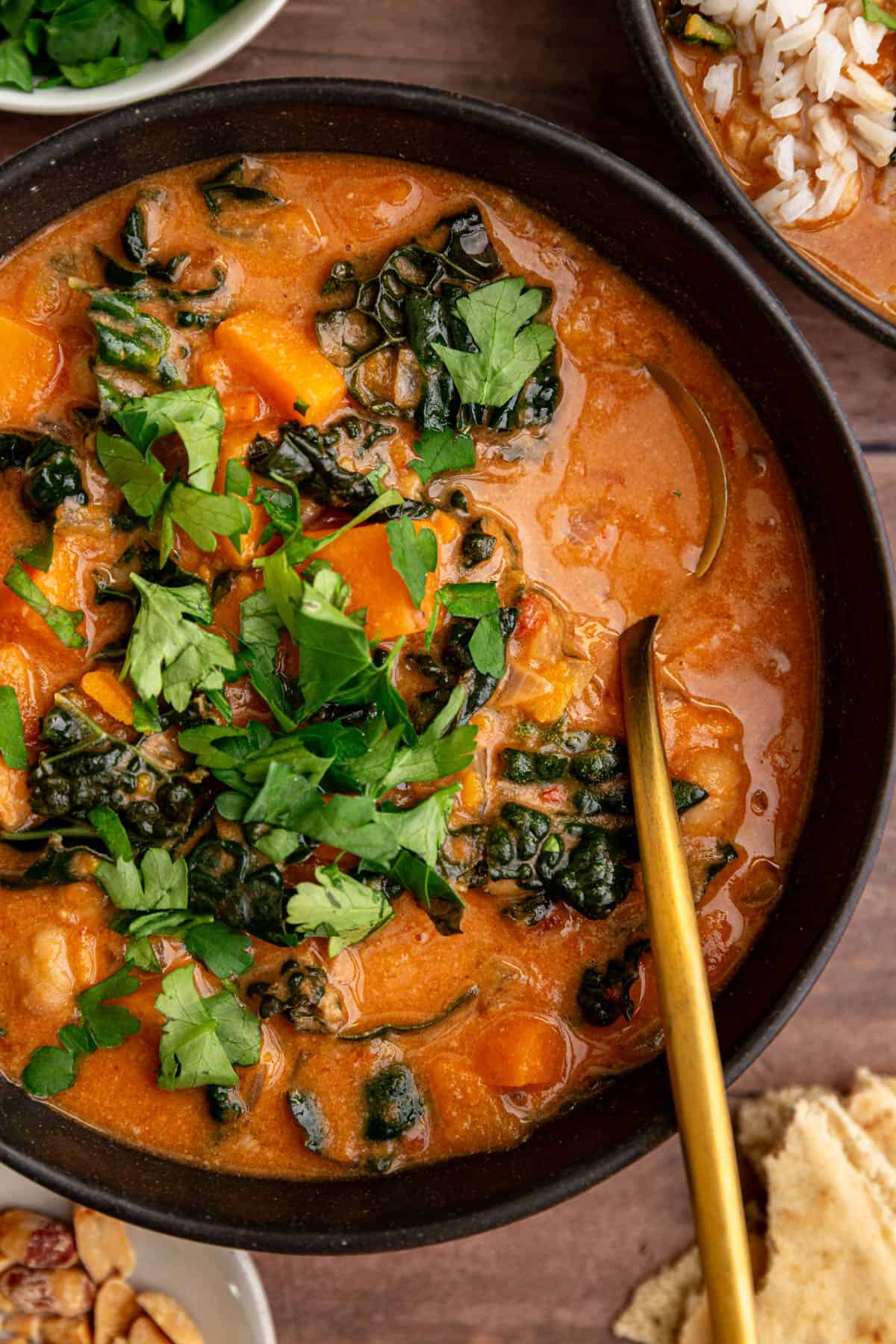 A bowl of Vegan African Peanut Stew, with a spoon resting in the bowl