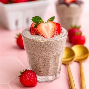 A jar of blended chia pudding, topped with strawberries.