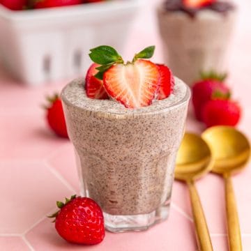 A jar of blended chia pudding, topped with strawberries.