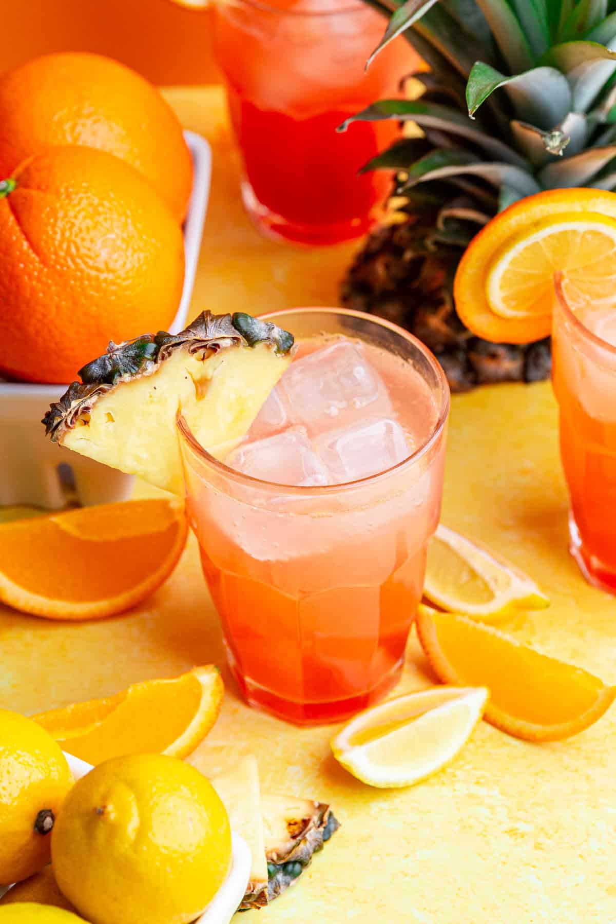 A glass of cinderella mocktail, surrounded by fresh fruit.