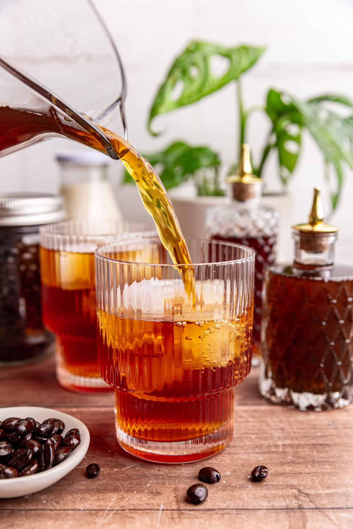 Cold brew being poured into a glass with ice.