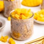 A jar of Vegan Mango Overnight Oats, topped with fresh mangoes.