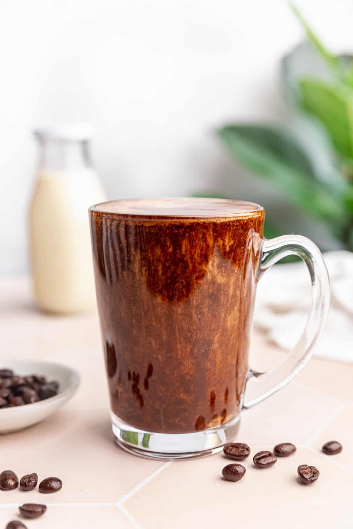 A mug of vegan protein coffee on a countertop.
