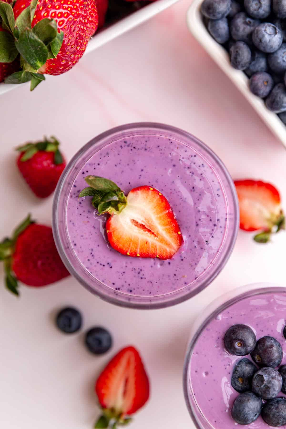 A glass of vegan protein smoothie, garnished with a strawberry.