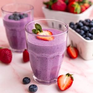 A jar of vegan protein smoothie, garnished with a strawberry.