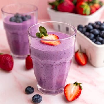A jar of vegan protein smoothie, garnished with a strawberry.