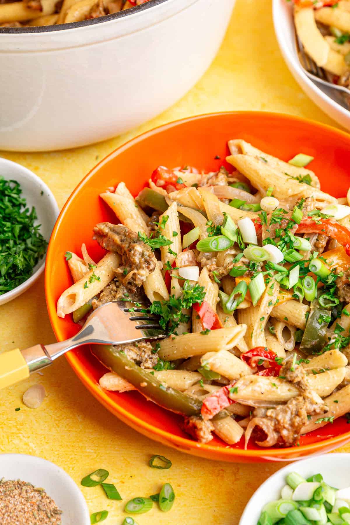 A bowl of vegan rasta pasta, with a fork, ready to eat.