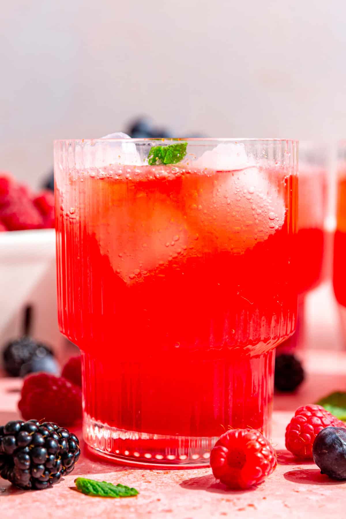 A side view of a glass of berry mocktail, to see the fizzy texture.
