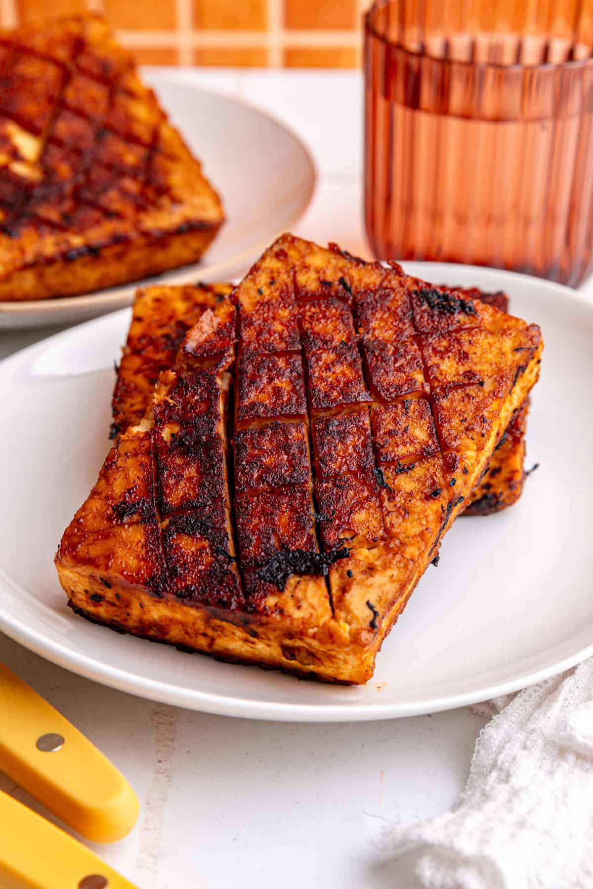 Two pieces of glazed tofu ham on a plate.